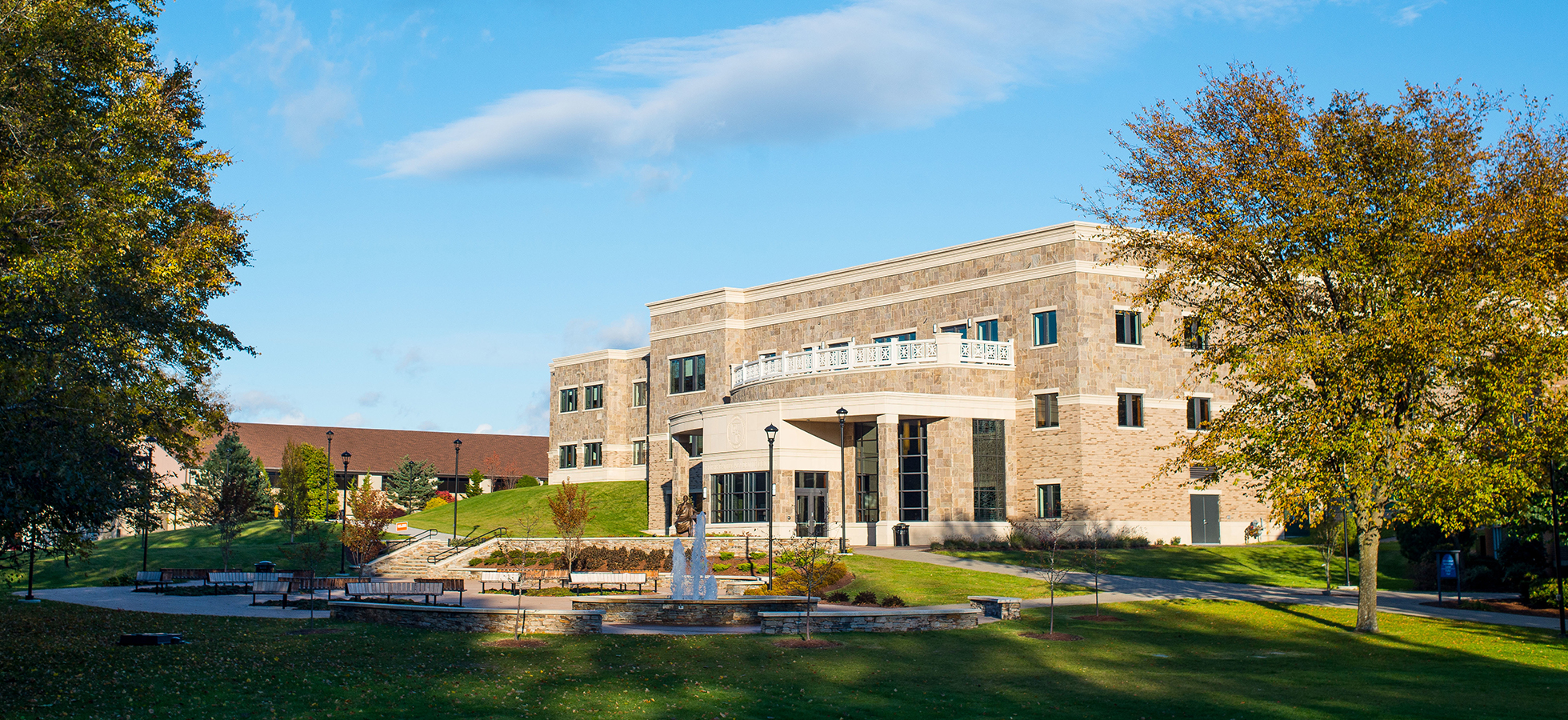 亚洲博彩网站 students sit outside of the new Tsotsis Family Academic Center.