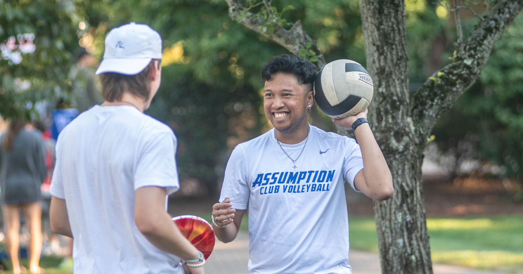 亚洲博彩网站 student holding a volleyball and wearing a shirt that reads 